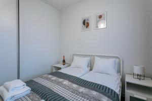 um quarto branco com uma cama e duas mesas de cabeceira em Apartament Bryza Jantar by TriApart em Jantar