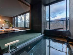 een badkamer met een dompelbad en uitzicht bij Fufu Hakone in Hakone