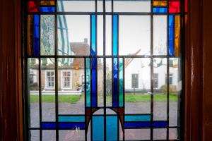 a stained glass window with a view of a street at Pension Westerburen in Schiermonnikoog