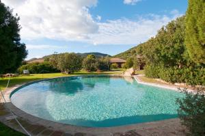 a large swimming pool in a yard with trees at Hotel Spartivento in Chia