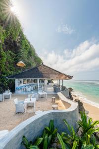 a restaurant on the beach next to the ocean at Karma Kandara in Uluwatu