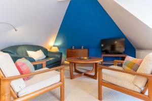 a living room with a couch and a tv at null Haus Achtern Poggendiek, Whg Spatzennest, OG in Sankt Peter-Ording