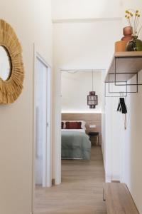 1 dormitorio con cama y espejo en Apartaments la rambla - Garnatxa - 4 persones, en Cornudella