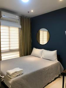 1 dormitorio con 1 cama con espejo en la pared en RedDoorz @ Occazia Hotel Pampanga en Bacolor