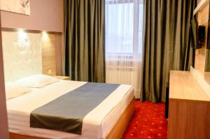 a hotel room with a bed and a window at Sun Rise inn in Karagandy