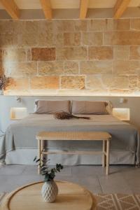 a bedroom with a bed and a brick wall at Marosi Boutique Hotel in Ciutadella