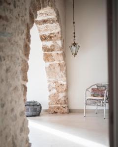 Habitación con silla y pared de piedra. en Can Alemany, en Santa Maragarida de Montbui