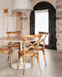 a dining room table with chairs and a light fixture at Can Alemany in Santa Margarita de Mombúy