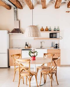 a kitchen with a table and chairs in a room at Can Alemany in Santa Margarita de Mombúy