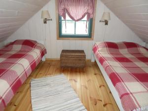 Zimmer im Dachgeschoss mit 2 Betten und einem Fenster in der Unterkunft Toidupada puhkemaja in Vidriku Asundus