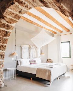 a bedroom with a bed in a stone wall at Can Alemany in Santa Margarita de Mombúy