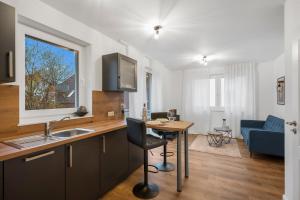a kitchen and living room with a desk and a table at Nadorst Residenz in Oldenburg