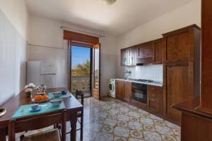a kitchen with wooden cabinets and a table in it at Villa Santina by BarbarHouse in Torre Colimena