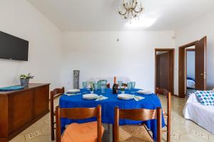 a dining room with a blue table and chairs at Villa Santina by BarbarHouse in Torre Colimena