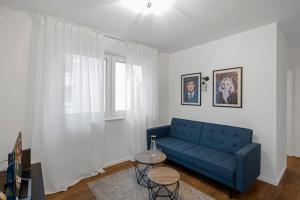 a living room with a blue couch and a table at Nadorst Residenz in Oldenburg