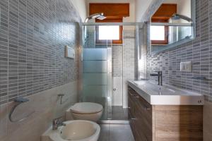 a bathroom with a toilet and a sink and a shower at Villa Santina by BarbarHouse in Torre Colimena +18 photos