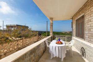 a table and chairs on a balcony with a view of the ocean at Villa Santina by BarbarHouse in Torre Colimena