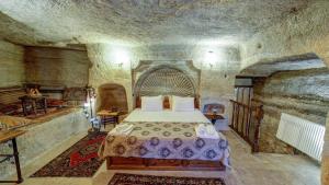 a bedroom with a bed in a stone room at Chelebi Cave House Hotel in Goreme