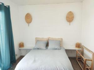 - une chambre avec un lit blanc et 2 oreillers dans l'établissement T2 Villa Rêve d'ailleurs St Leu, à Saint-Leu