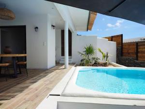 - une piscine dans une villa avec une table à manger dans l'établissement T2 Villa Rêve d'ailleurs St Leu, à Saint-Leu