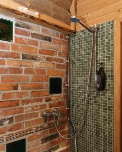 La salle de bains est pourvue d'un mur en briques et d'une douche. dans l'établissement Toidupada puhkemaja, à Vidriku Asundus