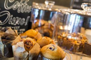 a bunch of different types of muffins on a table at Max Brown Hotel Canal District in Amsterdam