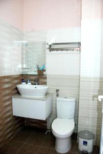 a bathroom with a white toilet and a sink at New Sleep in Dalat Hostel in Da Lat