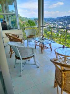 a balcony with chairs and tables and a view at Sky Valley in Kandy