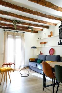 a living room with a blue couch and wooden ceilings at Apartaments la Rambla - Arbequina - 6 persones in Cornudella
