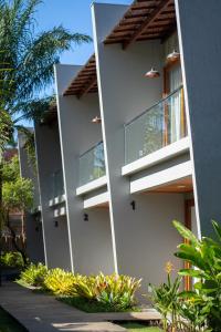 una fachada de un edificio con ventanas y plantas en PARAÍSO DO DENDÊ - FLATS, en Barra Grande