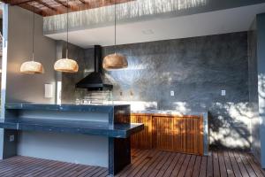 uma cozinha com um balcão azul e algumas luzes em PARAÍSO DO DENDÊ - FLATS em Barra Grande