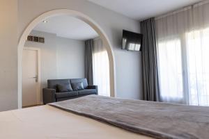 una camera con un grande letto e una sedia di Hotel Can Pamplona a Vic
