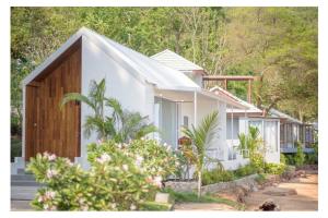 uma casa branca com árvores ao fundo em Seashell Village Resort em Praia de Chao Lao