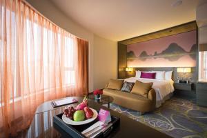 una camera d'albergo con letto e tavolo con cesto di frutta di Crowne Plaza Hong Kong Kowloon East, an IHG Hotel a Hong Kong