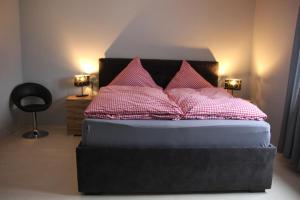 a bedroom with a bed with pink pillows on it at Weingut Schumacher - mit privatem Saunabereich in Sankt Aldegund