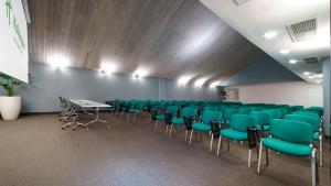 a conference room with green chairs and tables and lights at voco Nola - Naples Vulcano Buono by IHG in Nola