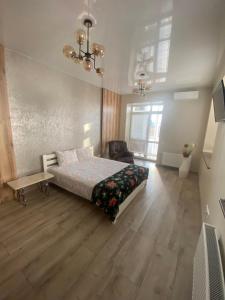 a bedroom with a bed and a chair in it at LUX apartment & центр,ЖК Театральний in Rivne