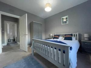 a bedroom with a bed with a white crib at Raploch House in Larkhall