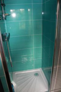 baño de azulejos verdes con ducha y suelo blanco en Le Haut Mesnil-3 en Mesnil-Follemprise
