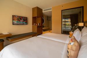 a bedroom with two beds and a large window at Pamookkoo in Kata Beach
