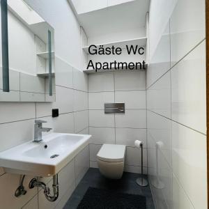 a white bathroom with a toilet and a sink at Haus Löhrberg in Hemer +15 photos