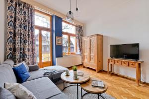 a living room with a couch and a tv at Apartamenty Tatra Club Centrum in Zakopane