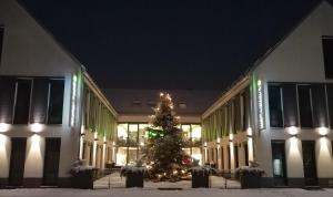 een kerstboom voor een gebouw 's nachts bij KH Hotel mit Restaurant in Geisenfeld