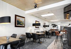 - un restaurant avec des tables et des chaises dans une salle dans l'établissement Østergaards Hotel, à Herning