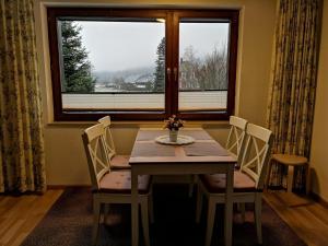 ein Esszimmer mit einem Tisch, Stühlen und einem Fenster in der Unterkunft C1 Schwarzwald-Fewo an der Alb 50m FerienwohnungApp für max 5 Personen in Menzenschwand