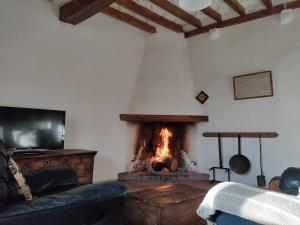 a living room with a fireplace and a couch at La Rectoria de Dosquers 24p in Maia de Montcal