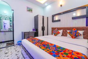 a bedroom with two beds with a colorful blanket at FabHotel Lumbini International in Varanasi