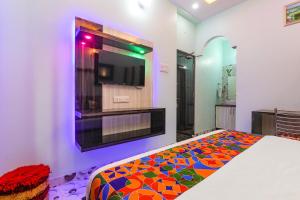 a bedroom with a flat screen tv on a wall at FabHotel Lumbini International - Nr Sarnath Museum in Varanasi +21 photos