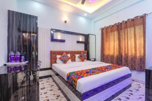 a bedroom with a large bed with colorful pillows at FabHotel Lumbini International in Varanasi