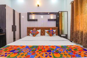 a bedroom with a bed with a colorful quilt at FabHotel Lumbini International - Nr Sarnath Museum in Varanasi
